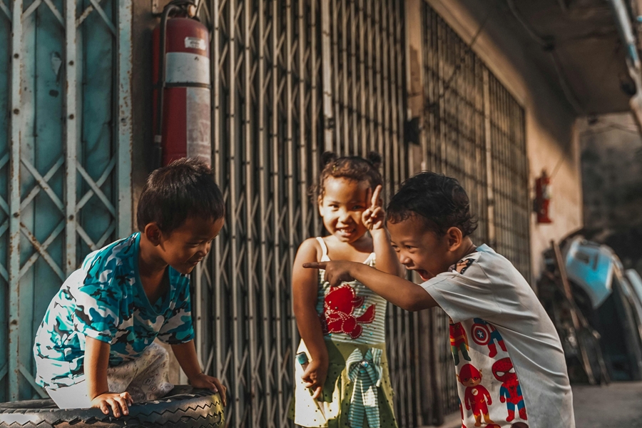 Kinderen spelen in een rustige straat in Bangkok