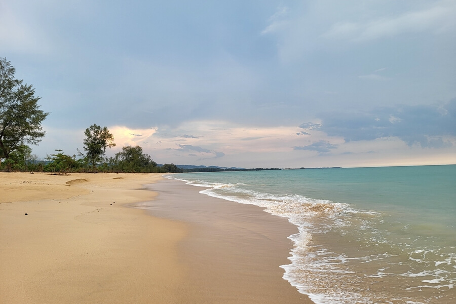 Rustig wit zandstrand van Khao Lak met helderblauw water en palmbomen