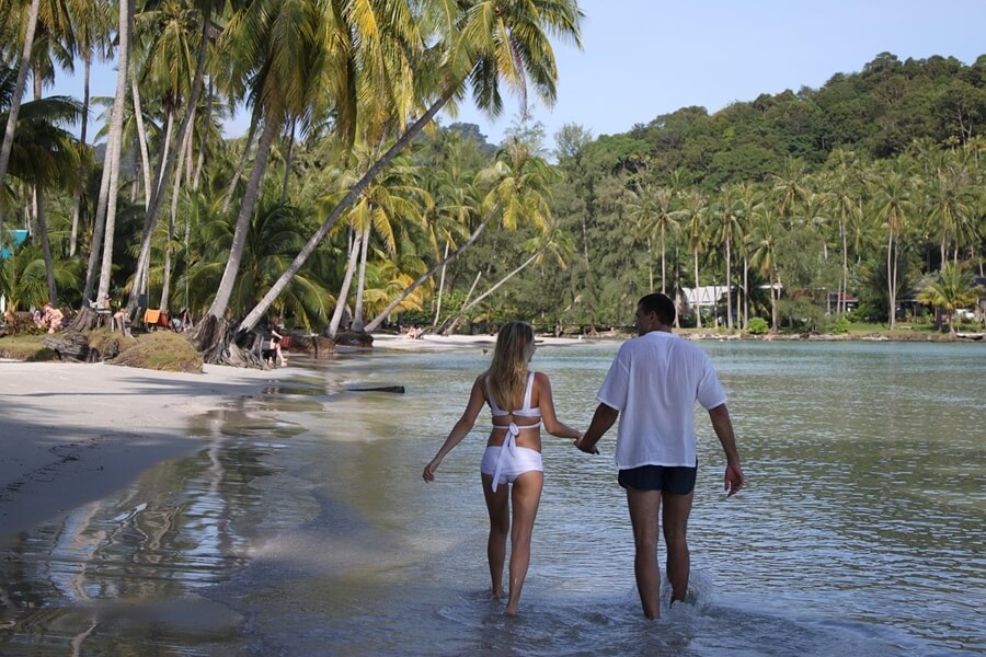 Stel wandelt in ondiep zeewater op Koh Kood