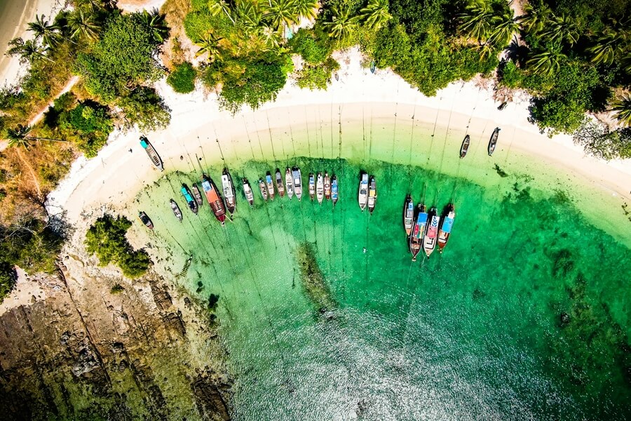 Bovenaanzicht van Koh Yao Yai met helderblauw water en longtailboten aan het strand